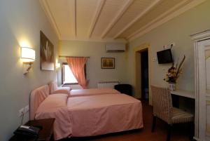 a bedroom with a bed and a desk and a window at Locanda San Barnaba in Scarperia