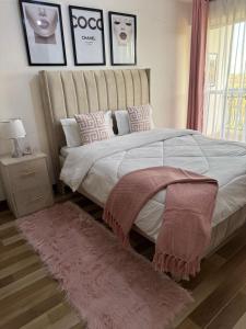a bedroom with a large bed with a pink rug at Kiambu Best Home in Nairobi +5 photos