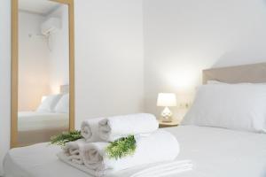 een slaapkamer met een bed met handdoeken en een spiegel bij VILLA 24 Sarandë in Sarandë