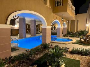 a villa with a swimming pool at night at Resort in Cairo