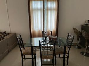 a dining room with a glass table and chairs at Vacation House with Private Pool in Baie du Tombeau
