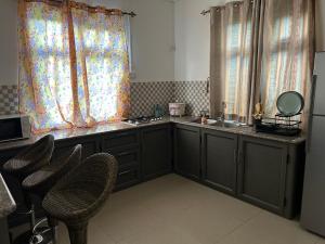 a kitchen with a sink and a counter with chairs at Vacation House with Private Pool in Baie du Tombeau +1 photo