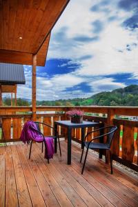 a patio with a table and chairs on a deck at Sielanka - Domki Całoroczne in Bezmiechowa Dolna