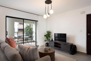 a living room with a couch and a tv at Plaza colonial suites by Yellowkey in Santo Domingo