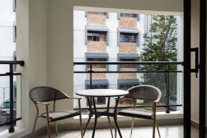 a table and chairs on a balcony with a window at Plaza colonial suites by Yellowkey in Santo Domingo