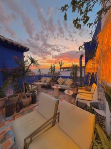 a patio with couches and chairs at sunset at Casa Amina in Chefchaouene
