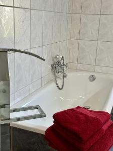 a bathroom with a bath tub with a red towel at FeWo am Kurpark in Schleiden