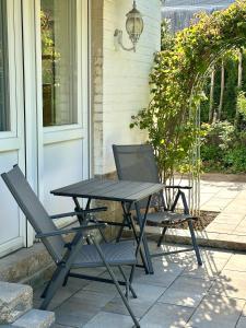 a picnic table and two chairs on a patio at FeWo am Kurpark in Schleiden
