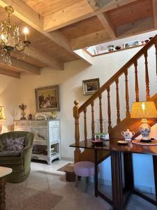 a living room with a table and a staircase at La Maison de Marie in Langonnet