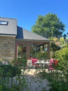 a screened in porch of a house with a table and chairs at La Maison de Marie in Langonnet +18 photos