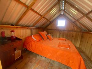 a bedroom with an orange bed in a cabin at Glamping Bugambilia in Subía
