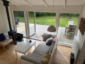a living room with a couch and a table at Liseleje sommerhus på naturgrund in Melby
