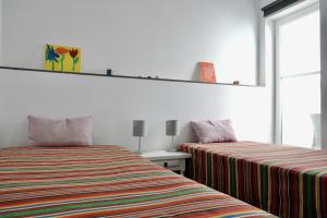 a bedroom with two beds and a table with a window at Tranquilidad y Naturaleza. Entre Volcanes y Mar in Presillas Bajas