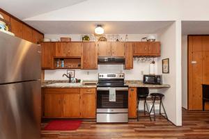 a kitchen with wooden cabinets and a stainless steel refrigerator at Private w Screened Porch, Deck & Dog-Friendly! in Luray