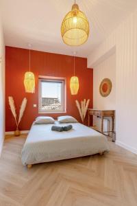 Un dormitorio con una cama grande con paredes rojas. en L'Instant Nîmois, en Nimes