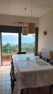 a dining room with a table and a large window at Lichada view in Likhás