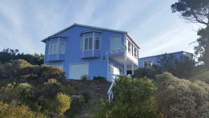 a blue house on top of a hill at The Mermaid's Tail in Pringle Bay