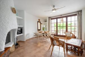 a living room with a fireplace and a table and chairs at Casa Saona En Riumar ( a 100m de la playa ) in Riumar