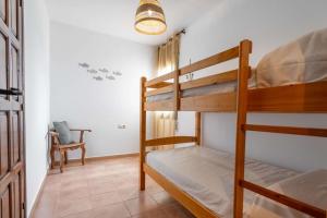 a bedroom with two bunk beds and a chair at Casa Saona En Riumar ( a 100m de la playa ) in Riumar