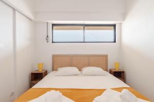 a bedroom with a large bed and a window at Gallarija Caparica in Costa da Caparica +20 photos