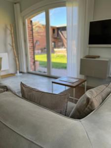 a living room with a couch and a tv at Ferienwohnung FÜNF Hof Himmelgrün in Saal