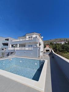 a large house with a swimming pool in front of it at Vila Kathy - kuća za odmor in Seget Vranjica