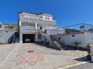 a large white house with stairs and a driveway at Vila Kathy - kuća za odmor in Seget Vranjica