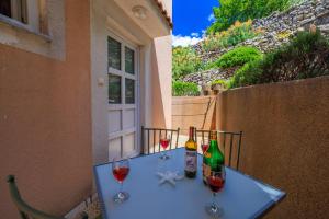 a table with two bottles and two glasses of wine at Apartments and rooms Bionda in Senj