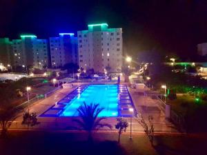 a large pool with blue lights in a city at night at Northern Cyprus, Trikomo, Iskele, Long Beach, Caesar Resort, 8 in Famagusta