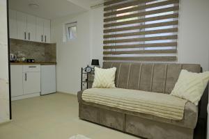 a living room with a couch and a kitchen at Apartmani kod kumašina in Kuršumlija