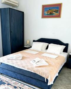 a bedroom with a large bed with towels on it at Apartments Mitrovići Miločer in Sveti Stefan