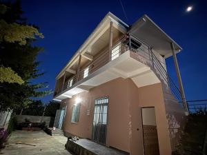 a building with a balcony with the moon behind it at Morina Rooms in Durrës