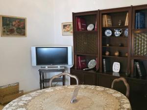 Un comedor con una mesa, un televisor y estanterías. en Casa 5 personas. Calle principal Cañuelas, en Cañuelas 7 fotos más
