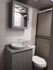 a bathroom with a sink and a toilet at Aparta Hostal in Santa Rosa de Cabal
