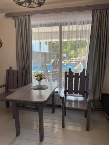 a dining room with a table and chairs and a window at Гостинний двір in Yaremche
