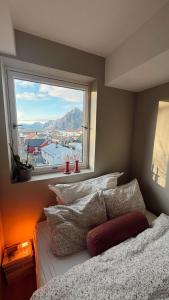 a bedroom with a window and a bed with pillows at Panoramic views in Henningsvær in Henningsvær