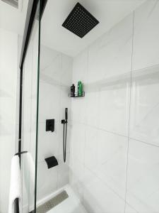 a white bathroom with a shower with a glass door at Gorgeous Two Bedroom Suite in a Quiet, Picturesque Neighborhood! in West Vancouver +19 photos