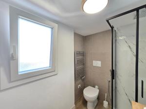 a bathroom with a toilet and a window at HomeholidaySanremo - Classic in Sanremo
