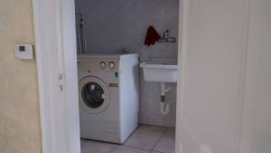 a small bathroom with a washing machine and a sink at Barbahouse in Monte SantʼAngelo