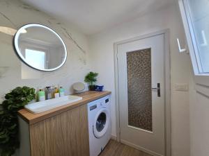 a bathroom with a sink and a washing machine at HomeholidaySanremo - Classic in Sanremo