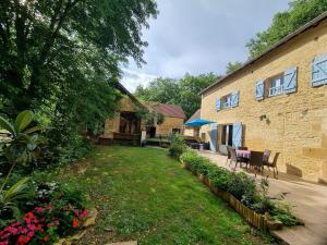 ein Hinterhof eines Hauses mit Stühlen und Blumen in der Unterkunft gite en pleine nature in Saint-Amand-de-Coly