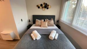 バラトンフゥルドヴァールにあるGOLDHOME Apartmanのベッドとタオル2枚のある寝室