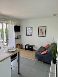 una sala de estar con un sofá y una mesa en Modern garden apartment, en Labenne