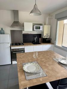 a kitchen with a table with a plate on it at Modern garden apartment in Labenne +7 photos