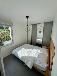 un dormitorio con una cama y una ventana en Modern garden apartment, en Labenne