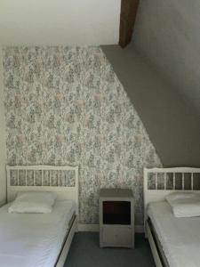 Veauville-les-BaonsにあるSalle Ancienne Ferme du Chateauのツインベッド2台 壁付きの部屋