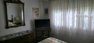 Un dormitorio con una cama, un espejo y un televisor. en Casa 5 personas. Calle principal Cañuelas, en Cañuelas