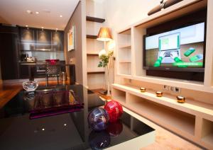 Una televisión o centro de entretenimiento en Nexus Valladolid Suites & Hotel