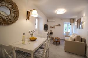 a kitchen and living room with a white table and chairs at Azure Haven in Hydra