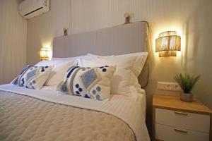 a bedroom with a large bed with white sheets and pillows at Azure Haven in Hydra